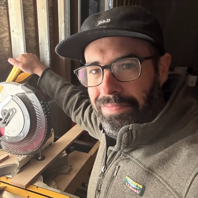 Jeremy Brault in the Second Shapes workshop, beside a miter saw.