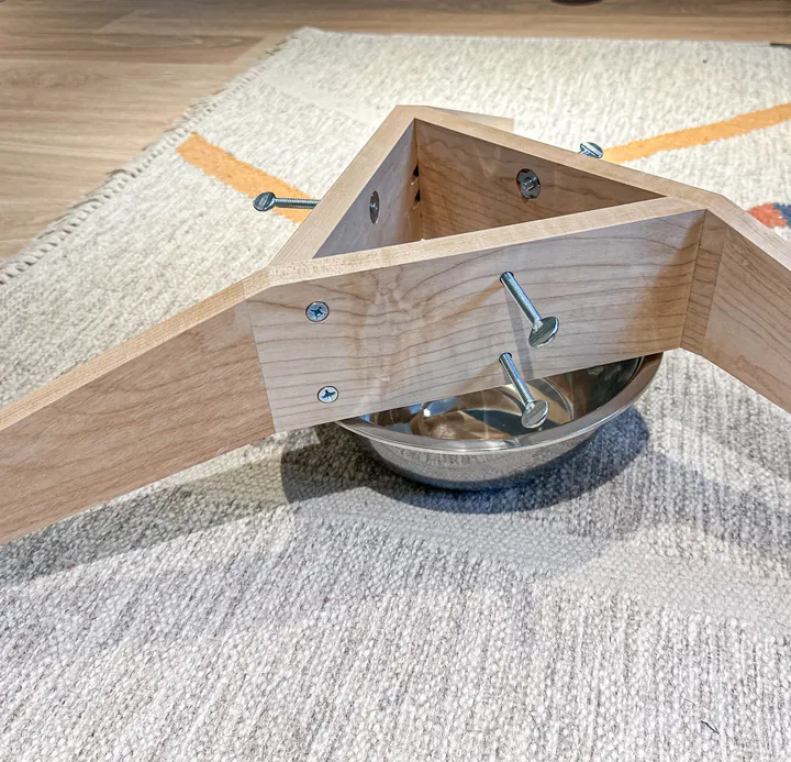 The triangular center, wood screws, thumb screws, and bowl of the assembled maple stand.