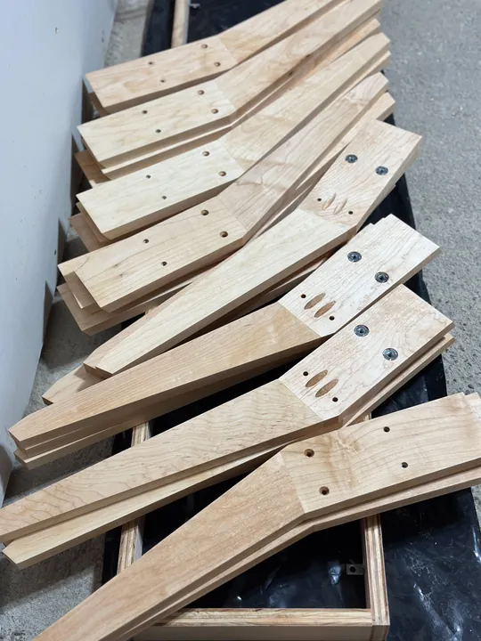 Drilled maple stand legs stacked diagonally across one another.