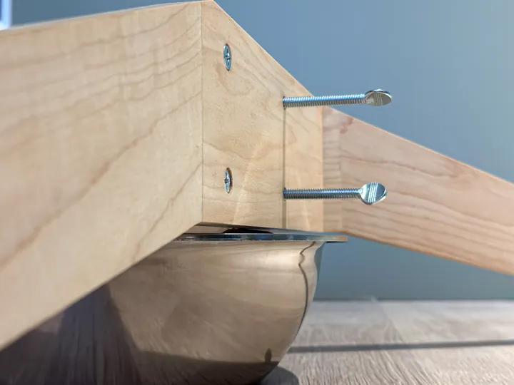 The maple side pieces, thumb screws, and bowl of an assembled stand.