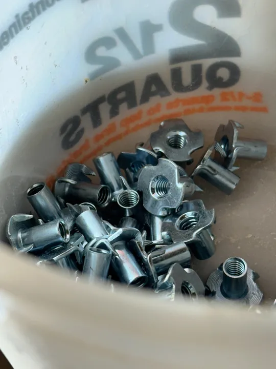 A container holding a batch of metal T-nuts.