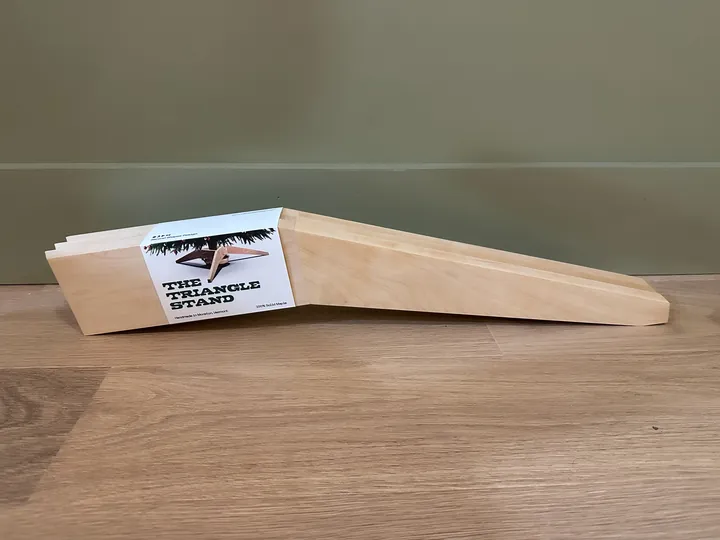 A stack of tapered maple stand legs with an illustrated paper wrap, viewed from the side.