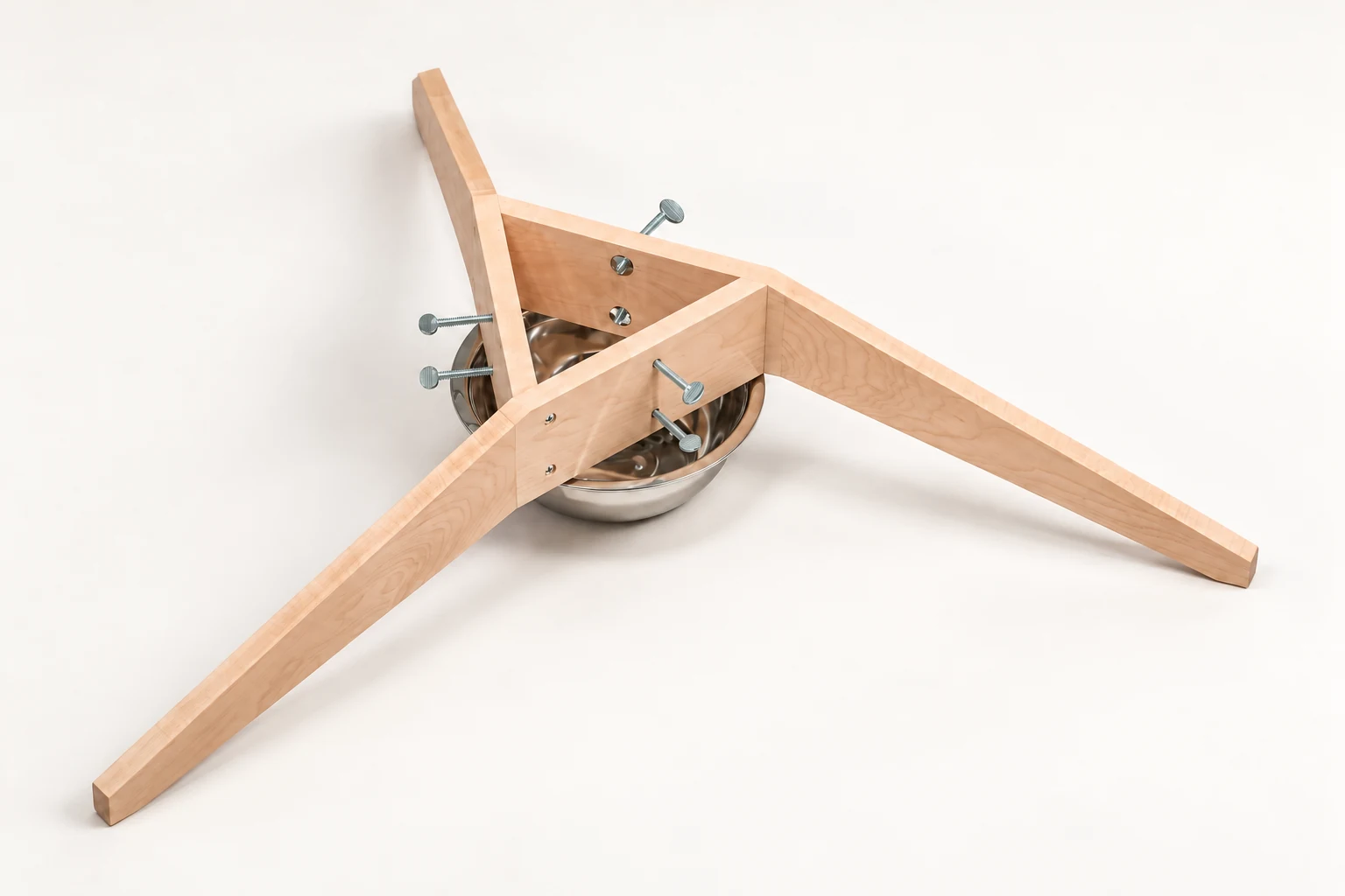 Studio view of the assembled maple Triangle Stand with its thumb screws and stainless steel bowl.